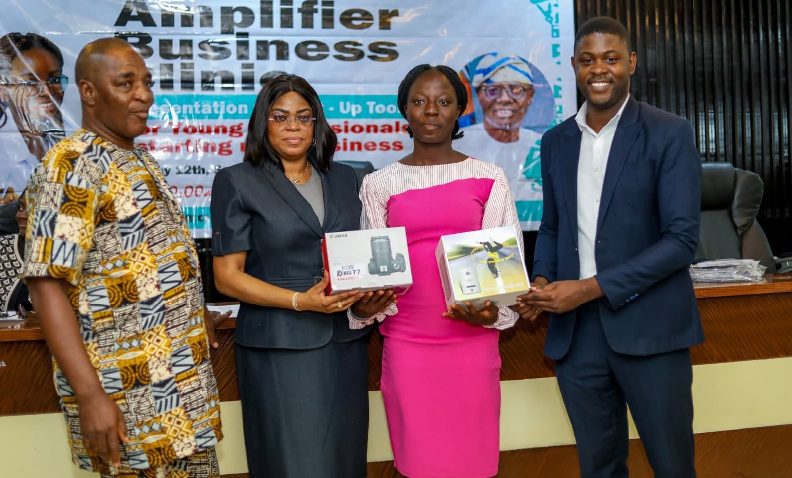 Programme officials presenting camera and broadband equipment grants to a participant